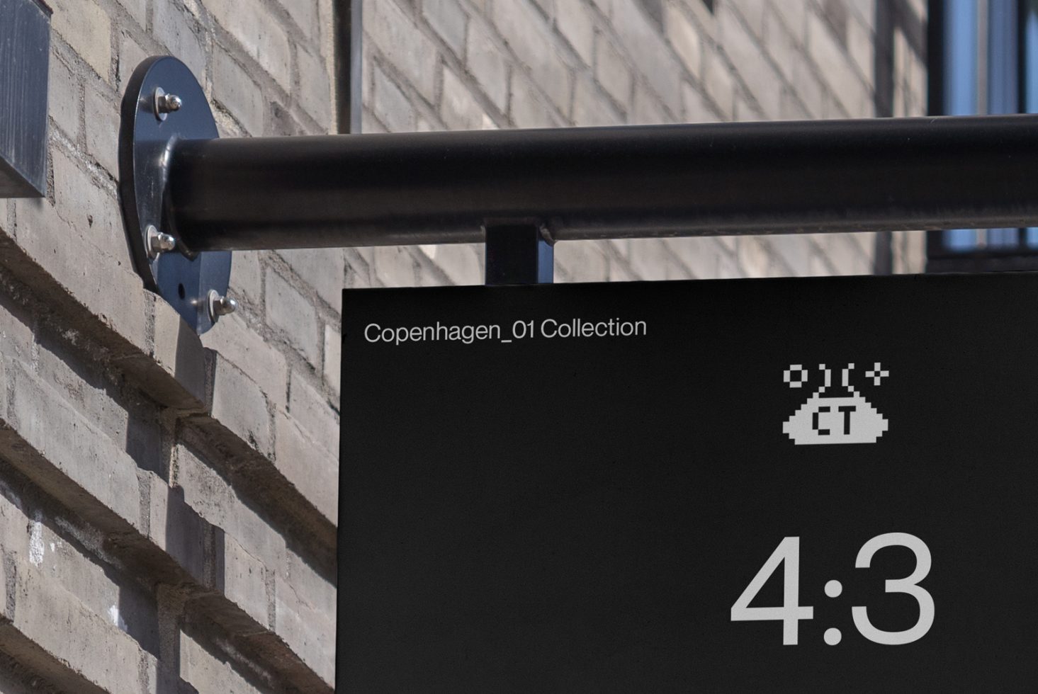 Street sign mockup on brick wall with contemporary black design and minimal text labeled Copenhagen_01 Collection, suitable for branding display.